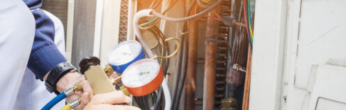 An HVAC technician checking an AC system in Nashua.