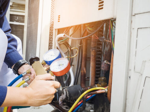 An HVAC technician checking an AC system in Nashua.