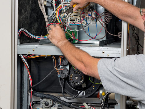 An HVAC tech working on a furnace