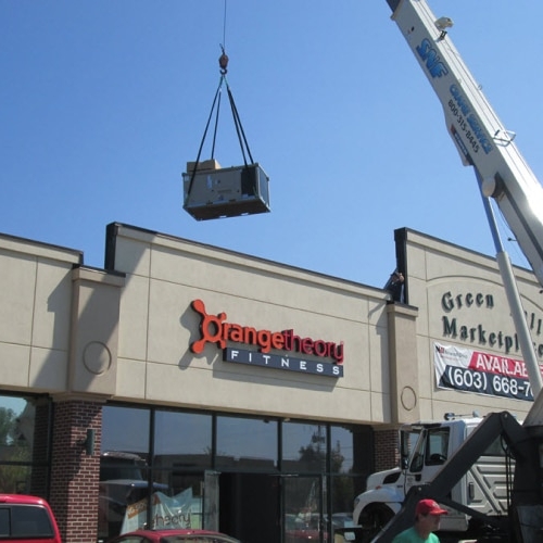 Commercial HVAC unit being installed on roof of business building