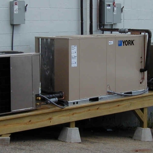 Commercial HVAC unit next to regular HVAC Units outside of building