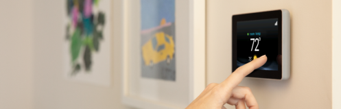 Woman setting a smart thermostat