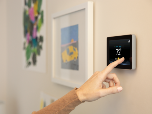 Woman setting a smart thermostat
