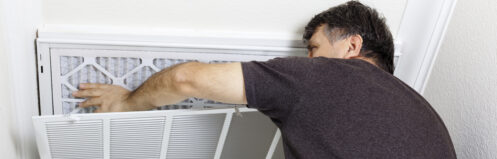 A man replacing an AC filter in Nashua, NH